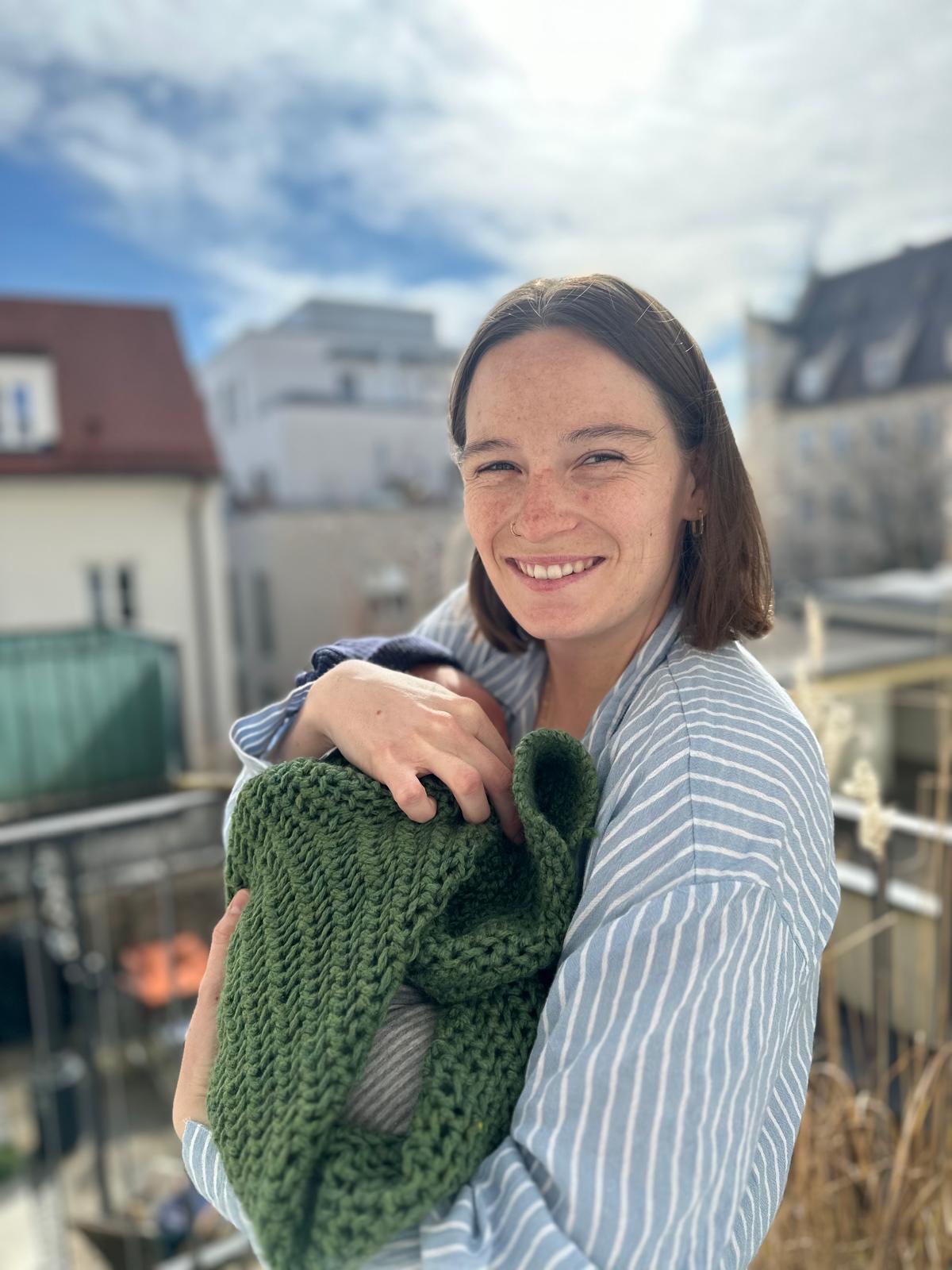Carla Schrott, Hebamme, mit einem Neugeborenen im Arm